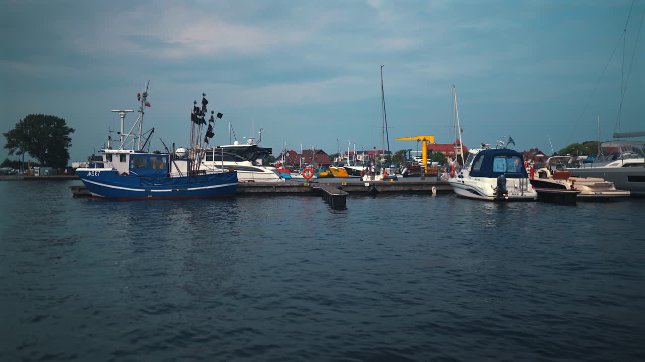 Yacht ormeggiati in un lussuoso porto turistico in una giornata estiva nuvolosa.