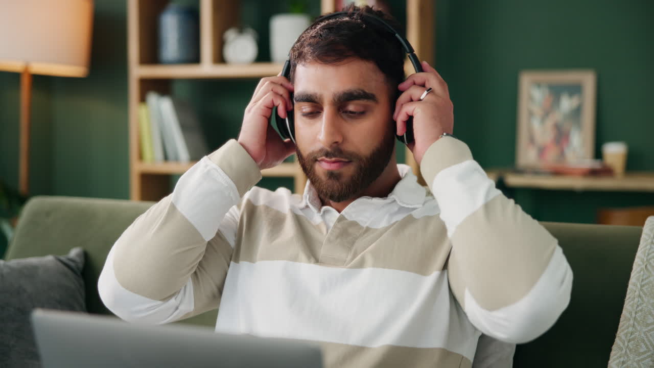 Man with headphones thinking at home