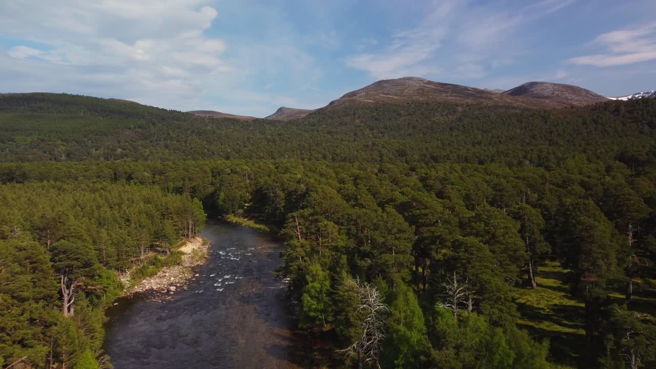 tiro de drone de campo de escocia de río y montaña en la distancia