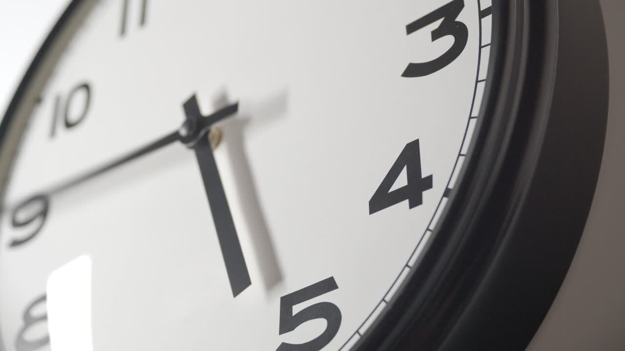 el reloj blanco se acerca en el lapso de tiempo en la pared blanca