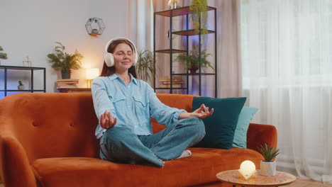 young woman listening music breathes deeply meditating with concentrated thoughts peaceful at home