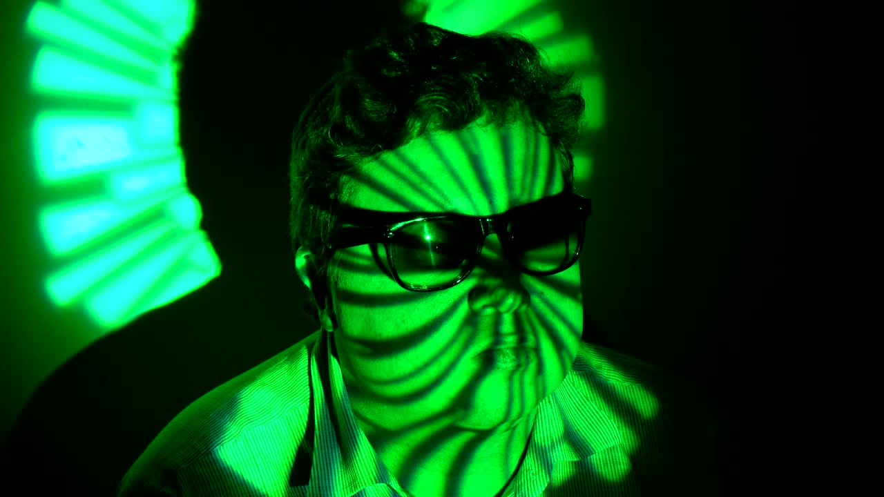 retrato de un hombre gordo en un haz de luz multicolor.