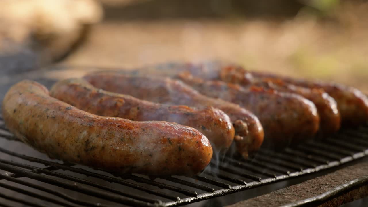 deliciosas salchichas jugosas, cocinadas en la parrilla con un fuego.