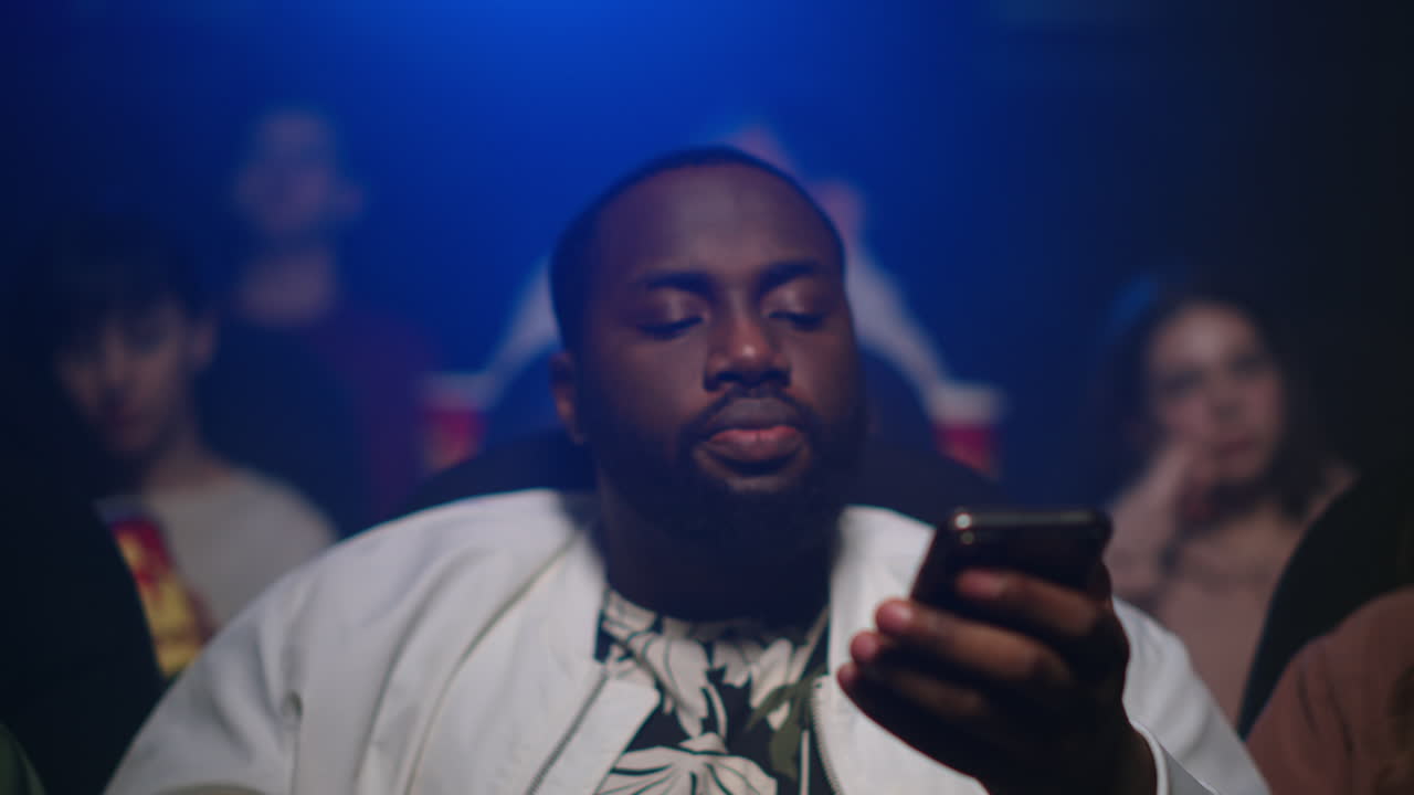 Afro man scrolling cellphone