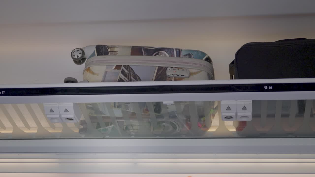 A luggage compartment with two suitcases in a train cabin during a journey