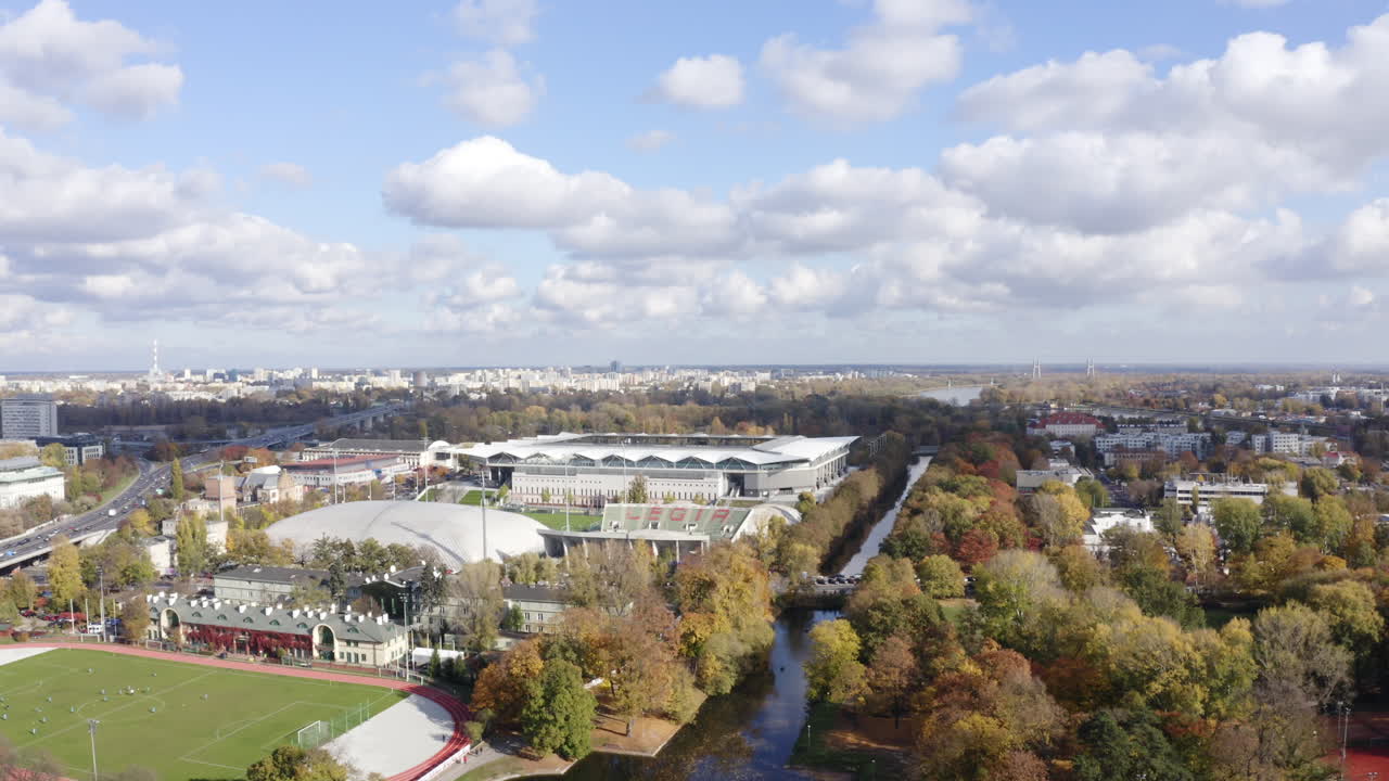 Aerial drone shot of Legia Warsaw stadium and cityscape in the day in Warsaw, Poland