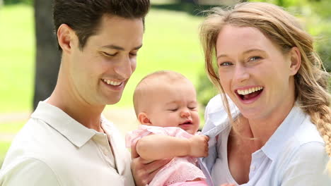 happy parents with their baby girl in the park