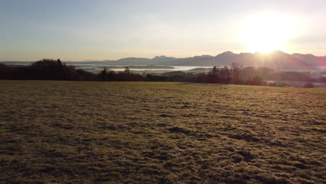 Flying-backwards-above-Meadow-in-Bavarian-Alps-during-Sunrise