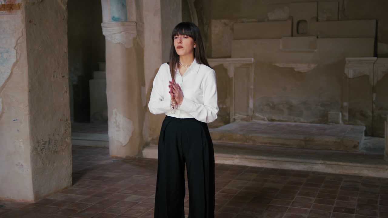 Devoted Young Woman Standing In The Church Praying With Hands Together