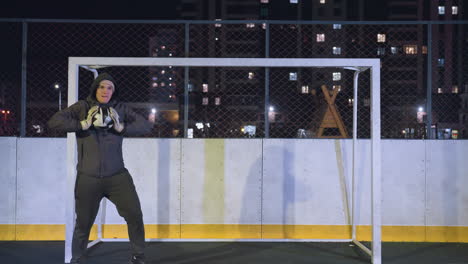 energetic goalkeeper showcasing agility and skills while dancing and catching a soccer ball during an intense practice session under vibrant nighttime city lights in an urban outdoor sports field