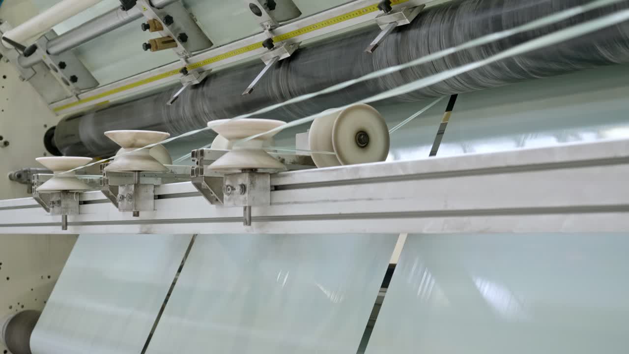 Modern Factory producing Plastic Foil and Plastic Bag. Inside Factory Line. Cellophane moves between the shafts. Polyethylene bags.