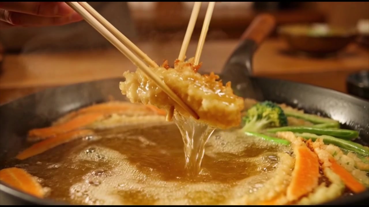 Chef che frigge verdure in tempura nell'olio bollente