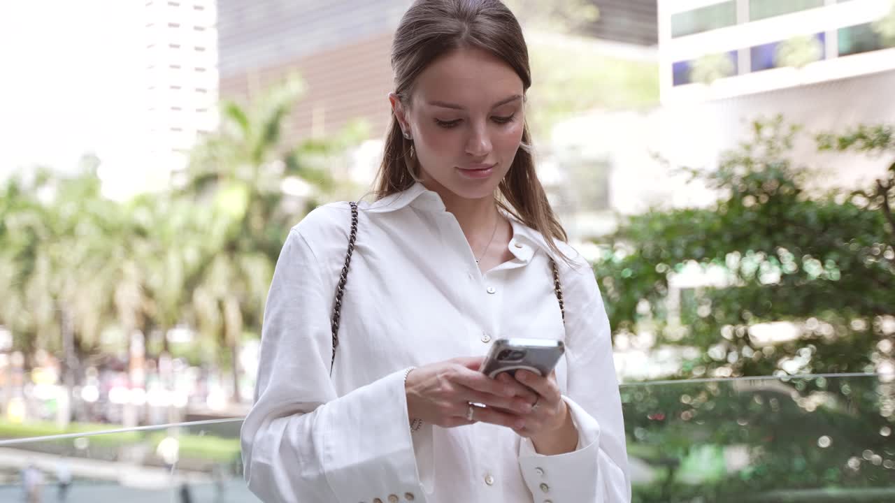 mujer joven usando teléfono inteligente en la ciudad