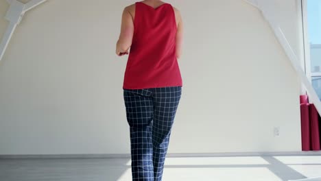 woman walking in a room with a big window