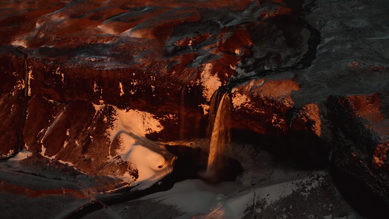 fotografía aérea del establecimiento de la gigantesca cascada en la isla de islandia al atardecer dorado