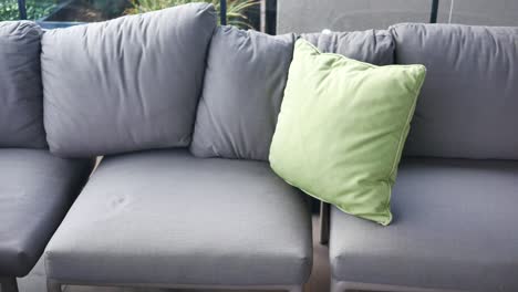 gray outdoor sofa with green pillows