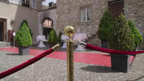 elegant outdoor event entrance with red carpet and gold stanchions – wedding or gala setup