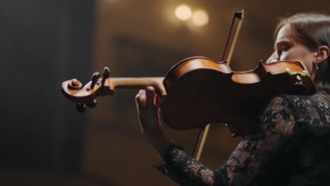 Hermosa-Mujer-Está-Tocando-El-Violín-En-La-Oscuridad-De-La-ópera-Retrato-De-Una-Violinista-Femenina-Con-Violín