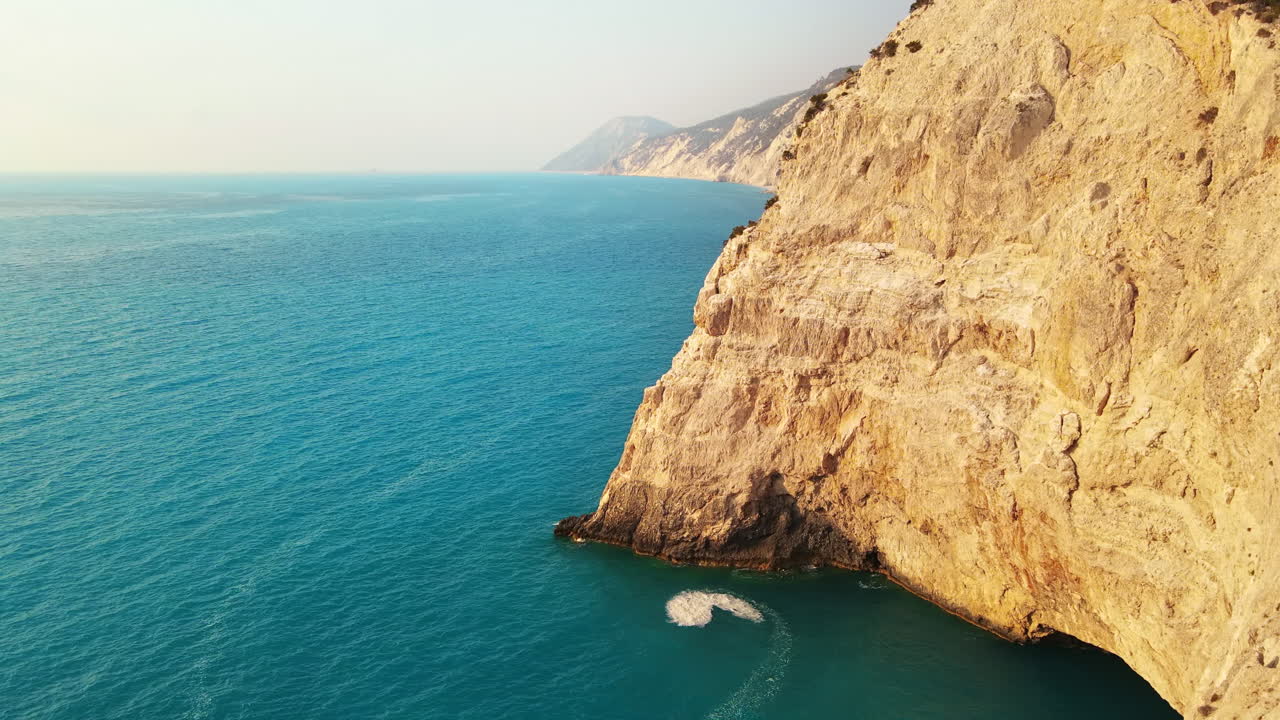Aerial drone view of the Ionian Sea coast of Zakynthos, Greece. Rocky cliffs, vegetation, blue water. Sunset