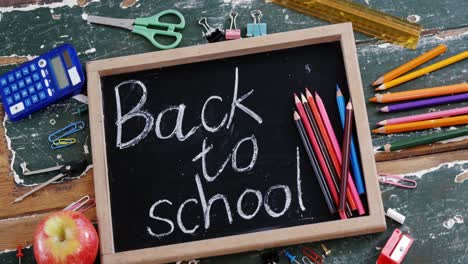 text written on slate with school supplies