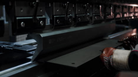 close up of factory worker molding a steel plate on a hydraulic press