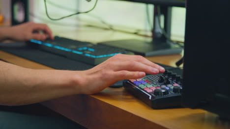 close up of male vlogger using computer keyboard and editing control for live stream