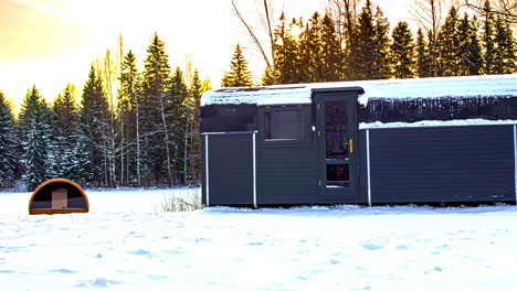 exterior of a glamping cottage on snow-filled landscape in wintertime