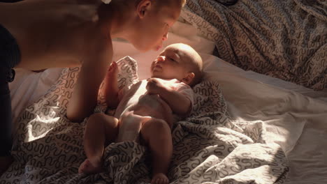 brother expressing love to baby sister with kiss