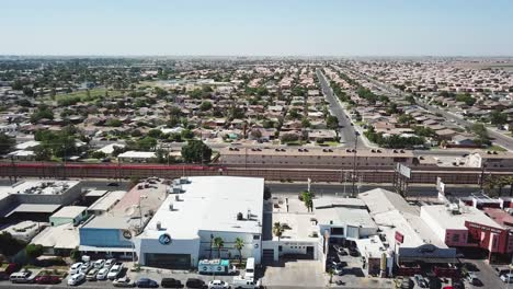 Vista-De-Un-Dron-Inclinado-Hacia-Arriba-Y-Volando-Hacia-La-Frontera-Entre-Estados-Unidos-Y-México