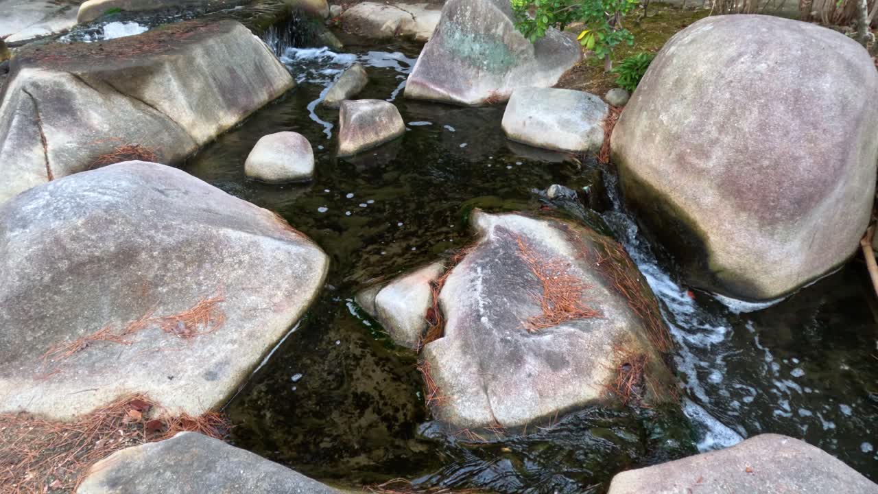 부드러운 물줄기가 부드러운 돌 위에 폭포로 흐르고 있습니다.