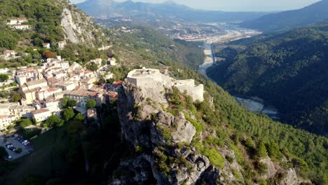 flying around the castle of gilette, typical village in south of france, with houses, mountains and river in the valley