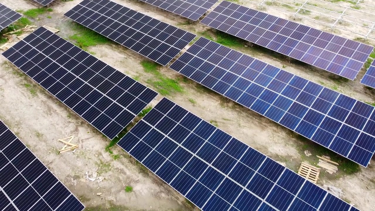 Ripresa aerea con tilt davanti a pannelli solari appena installati in un impianto fotovoltaico