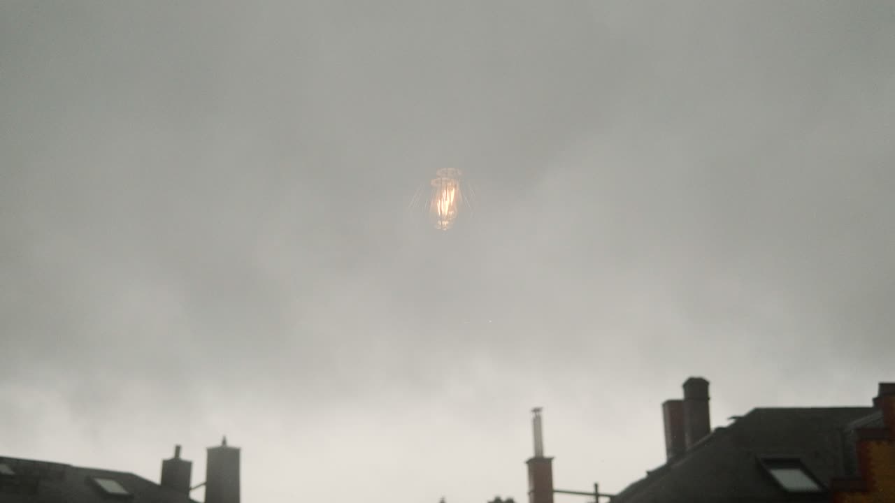 Light Bulb Reflection in a Cloudy City Sky