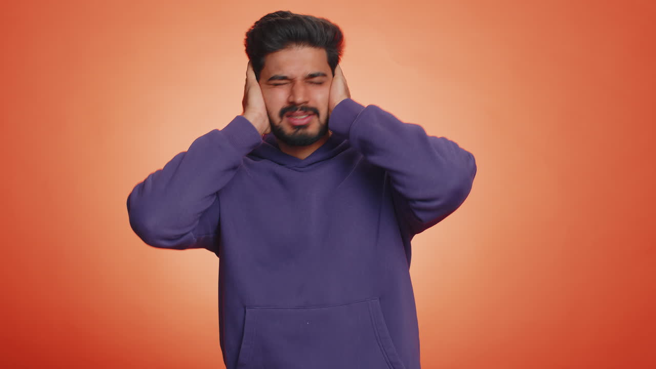 Irritato irritato bel uomo che copre le orecchie gesticolando non evitando consigli ignorando il rumore le voci forti