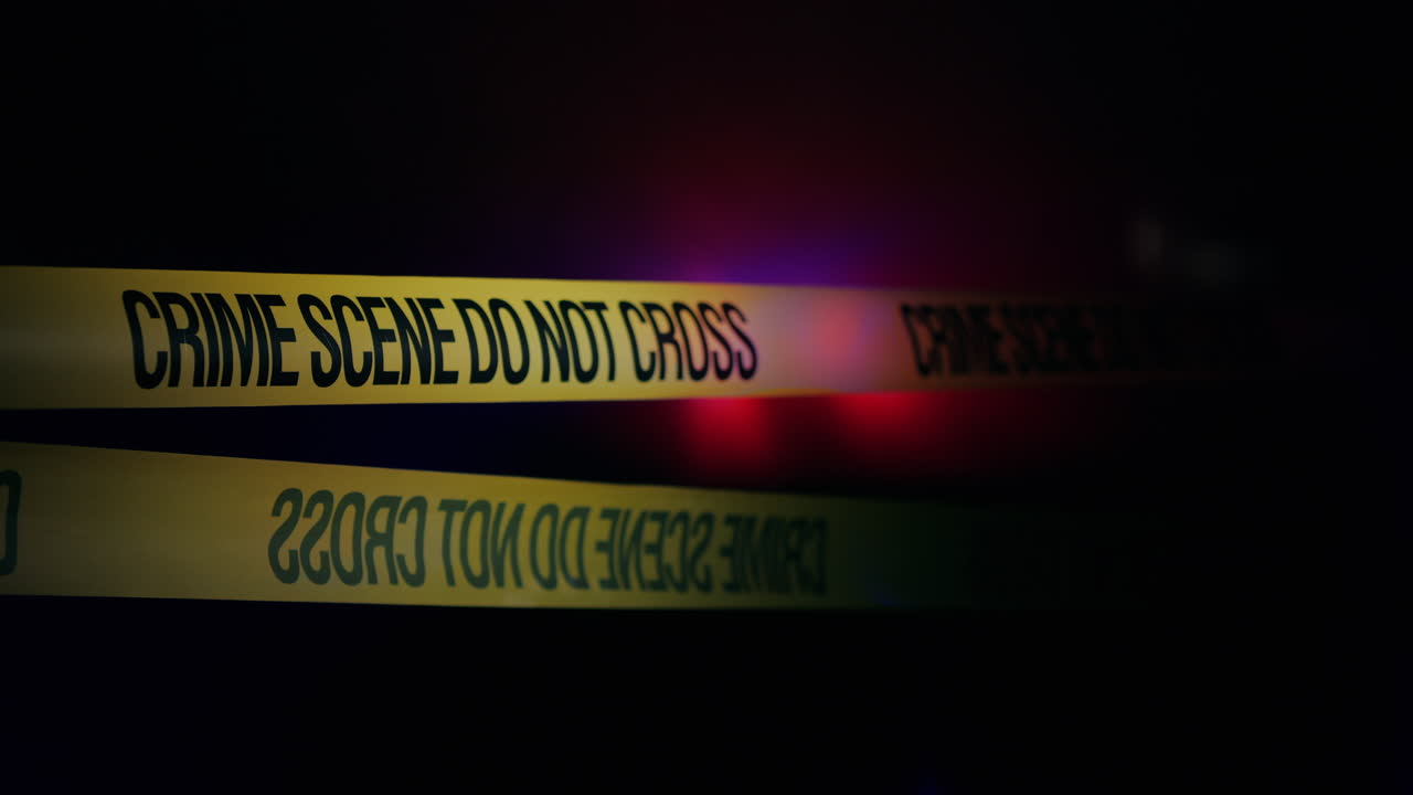 cintas amarillas encierran la escena del crimen iluminada por luces policiales