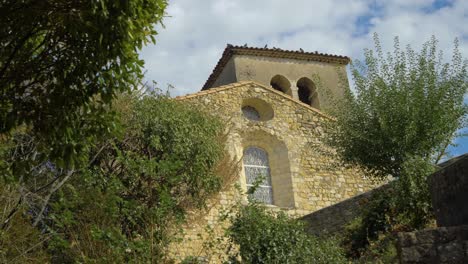 Campanario-De-Una-Iglesia-Provenzal-Bajo-Un-Cielo-Soleado-En-Cámara-Lenta-En-Verano