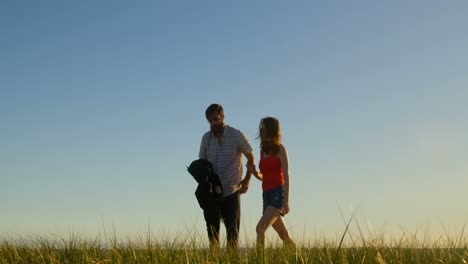 Young-couple-walking-together-on-the-beach-4k