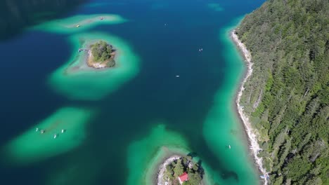 group of small islands near a lake surrounded by green trees some of the islands appear to be connected by a small bridge small boats intriguing yet light hearted visual birds drone view cinematic