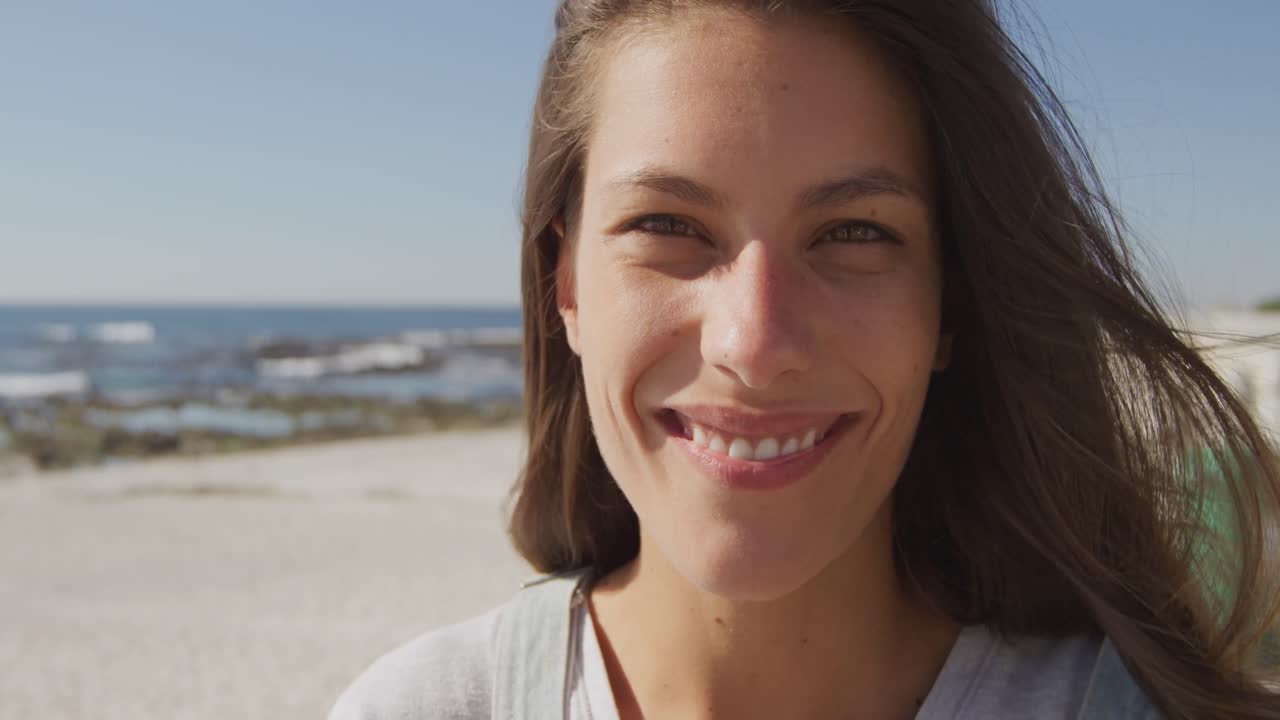 retrato de una mujer joven sonriendo en una playa