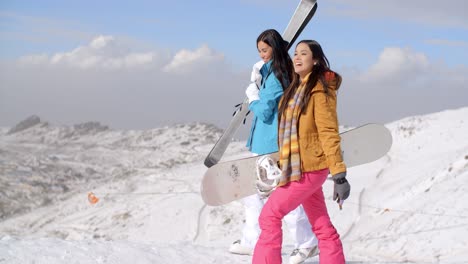 two friends hiking up ski slope