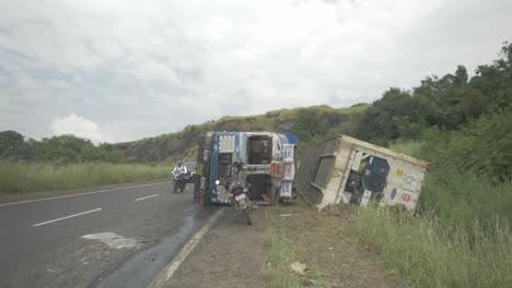 A-lorry-truck-carrying-a-cold-storage-container-toppled-in-an-accident-due-to-oversteering-on-a-downhill-ghat-section-on-an-Indian-highway-in-4k-slow-motion