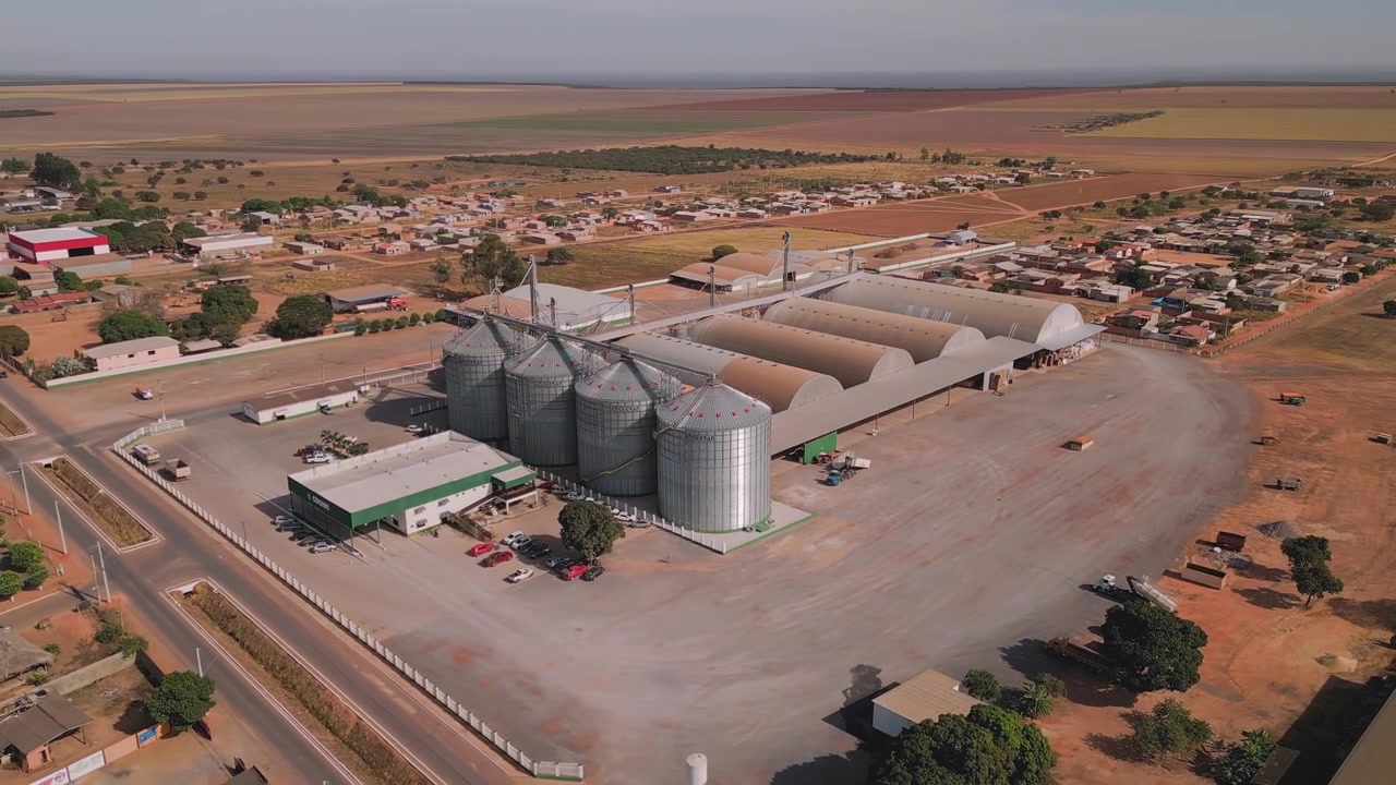 Vista aérea de uma grande instalação de armazenamento de grãos com silos e armazéns. Tomada de drone orbital mostrando um complexo de agronegócio no Brasil