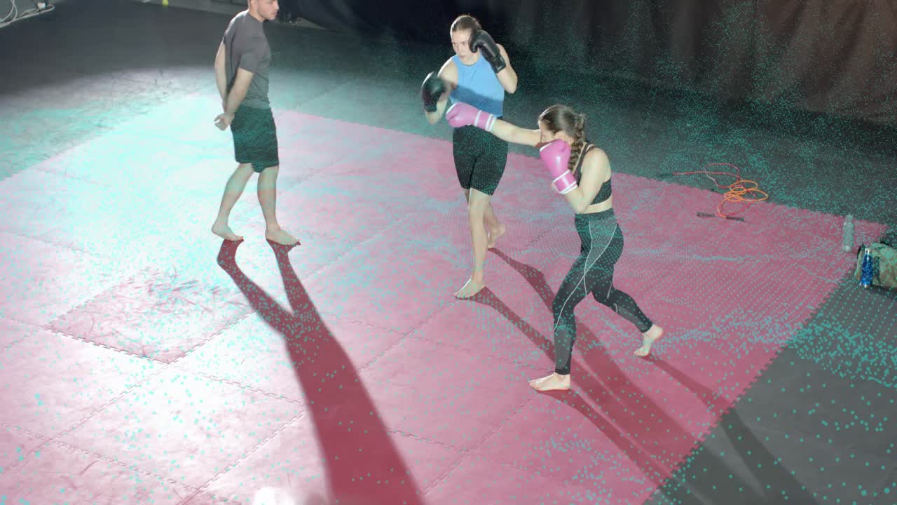 Coach cueing boxing drill, two trainees sparring on mats, throwing jabs and counters for practice