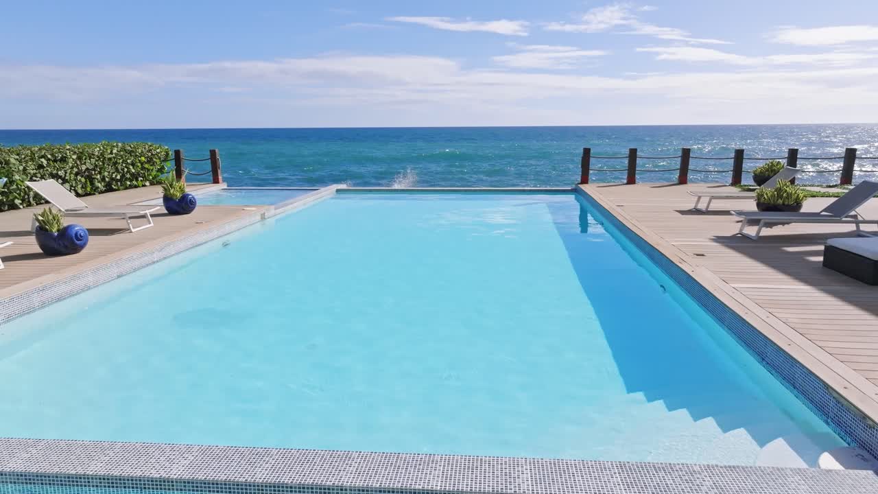 Luftfoto af infinity-swimmingpool i hotelområde med udsigt over Det Caribiske Hav og stenstrand - Den Dominikanske Republik, Juan Dolio.