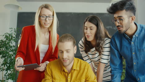 grupo de jóvenes empresarios multiculturales de inicio hablando y trabajando juntos frente a la computadora