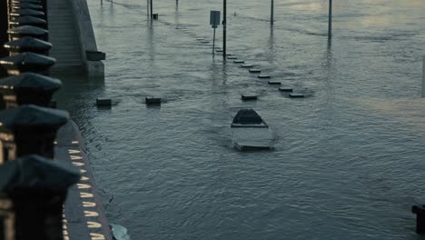 submerged street and benches underwater during the budapest flood 2024 along the danube river in front of the parliament building