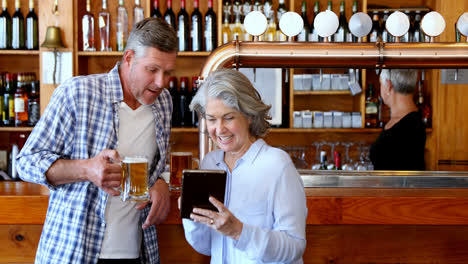 friends using digital tablet while having beer at counter 4k