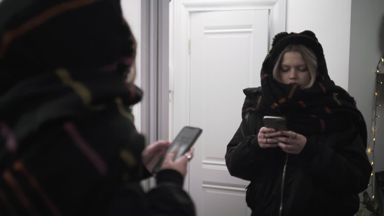 adolescente usando el teléfono móvil en la puerta