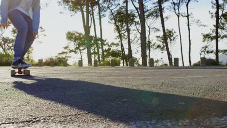 front view of young male skateboarder riding on skateboard on country road 4k