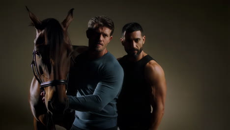 two men and a horse in dramatic lighting